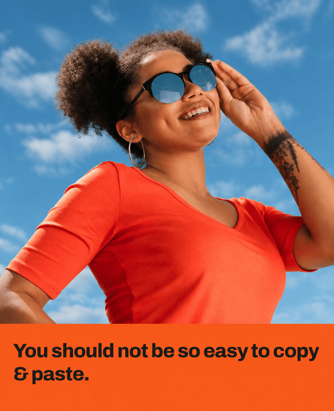 Woman in an orange top and sunglasses outdoors